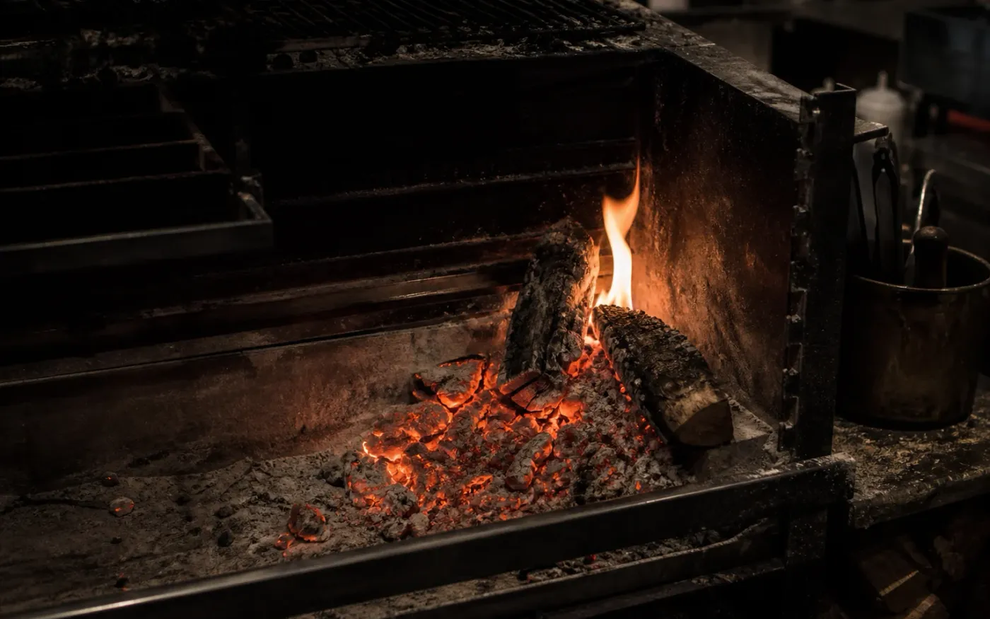 Glowing embers and flame in a working restaurant hearth